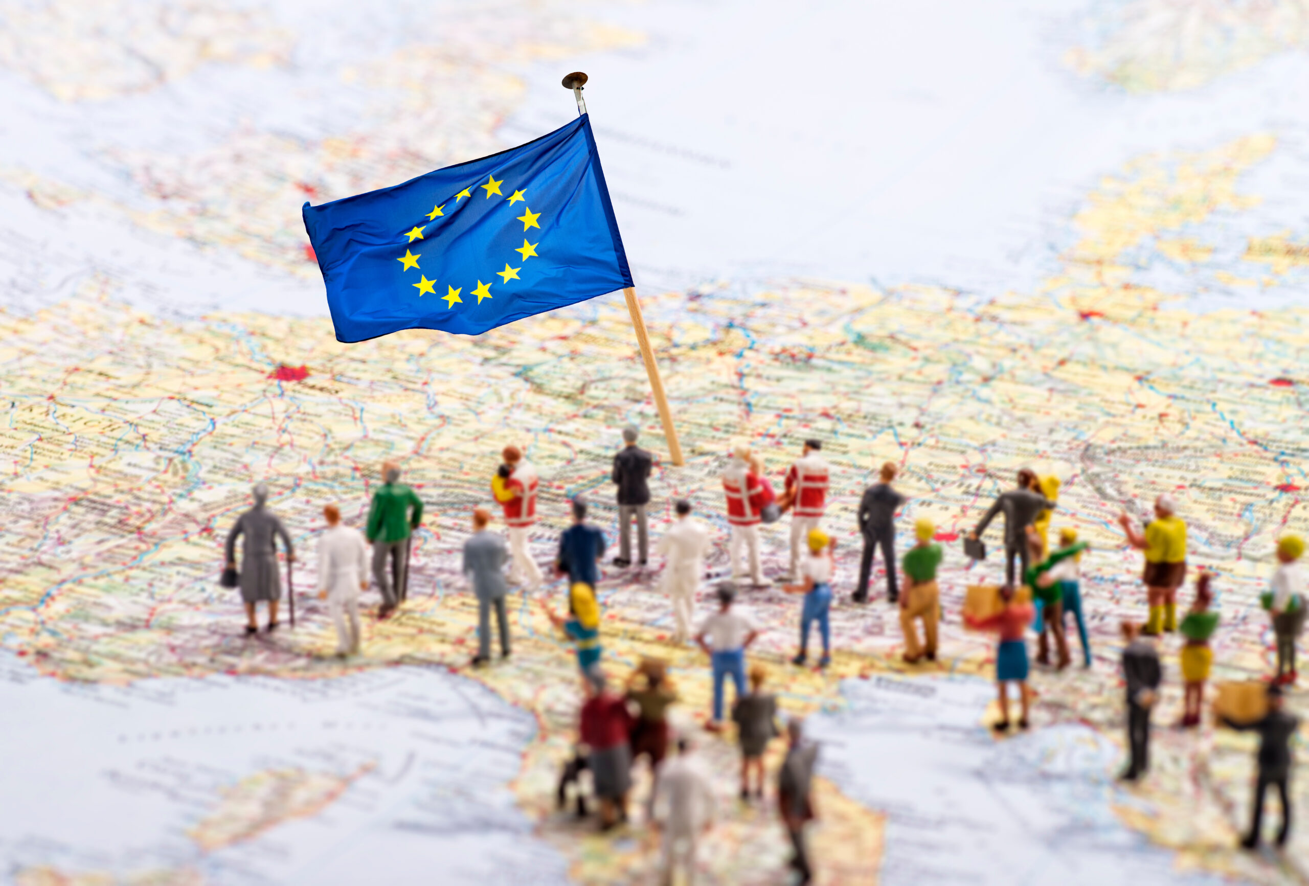 Europakarte mit Europäischer Flagge und einer großen Gruppe mit Figuren.